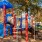 a playground with trees and a slide